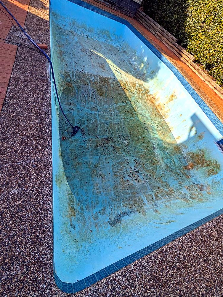 Stained, faded pool interior before work